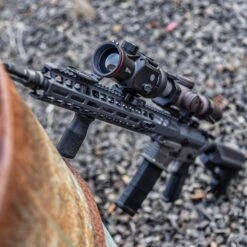 IRay Mate MAH50 | 50mm Clip-On Thermal W/ 2400 Yard Range 37 IRay Mate MAH50 | 50mm Clip-On Thermal W/ 2400 Yard Range -Tactical Equipment gallery image rifle equipped with iray mate mah50 leaning on rusty drum with bullet holes ammos and casings